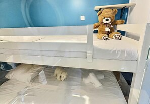 Ein Etagenbett mit einem Teddybären im oberen Bett.