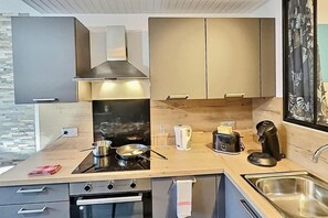 Eine moderne Küche mit Herd, Wasserkocher, Toaster und Spüle.