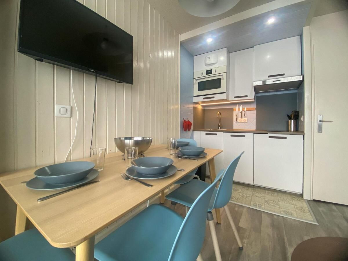 A compact kitchen with white cabinets, a microwave, and a built-in oven.