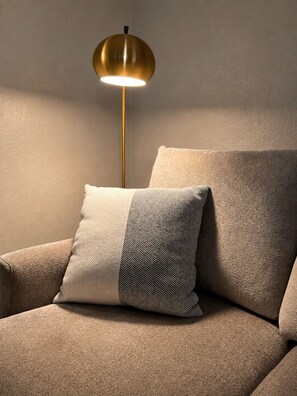 A sofa with a textured cushion and a floor lamp with a metallic shade. - Pet-Friendly Central Austin Bungalow - Near Hospitals, Tech Corridor & Downtown (Austin)
