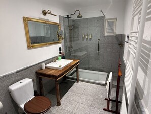 A bathroom with a toilet, sink, mirror, shower, and bathtub.