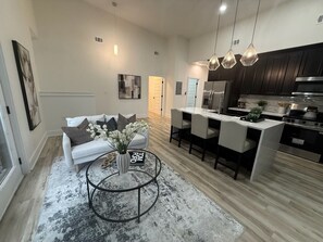 A modern kitchen with dark cabinets, a central island, and pendant lighting. - Sweet Atlanta Escape (Atlanta)