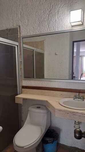 Ein Badezimmer mit Toilette, Waschbecken und Spiegel.