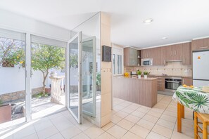Eine moderne Küche mit Schiebetüren, einem Essbereich und Blick auf einen Garten.
