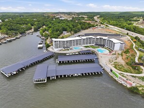 A waterfront hotel with multiple docks, a swimming pool, and a large building with a curved roof.
