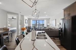 A modern kitchen with a central island, built-in appliances, and a view to the outdoors.