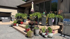 A patio area with outdoor furniture, a grill, and various potted plants. - Niagara River Idyll
Luxurious Queen size bedroom with own bathroom (Stevenstille)