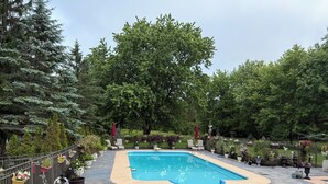 A swimming pool surrounded by potted plants and outdoor furniture. - Niagara River Idyll
Luxurious Queen size bedroom with own bathroom (Stevenstille)