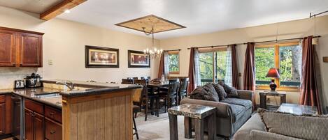 A spacious living area with a kitchen, dining table, and a sofa.