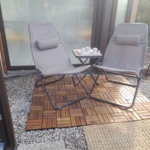 Two lounge chairs with cushions, a small table with a tray of cups, and a herringbone-patterned wooden floor. - Apartment in Cap Ferret, across from Phare Beach (Lège-Cap-Ferret)