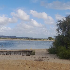 A sandy beach with a wooden fence, a body of water, and boats. - Apartment in Cap Ferret, across from Phare Beach (Lège-Cap-Ferret)