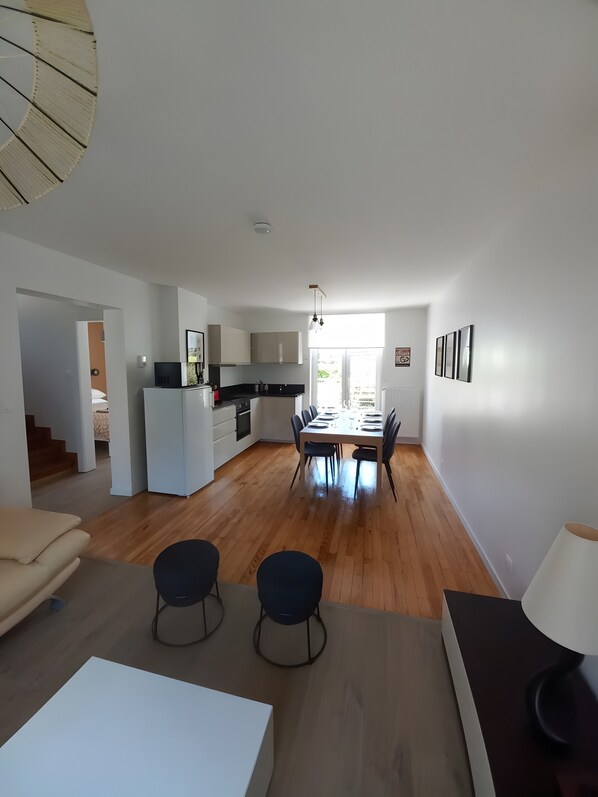 Eine moderne Wohnung mit Essbereich, Küche und einer Treppe, die zu einer weiteren Ebene führt.