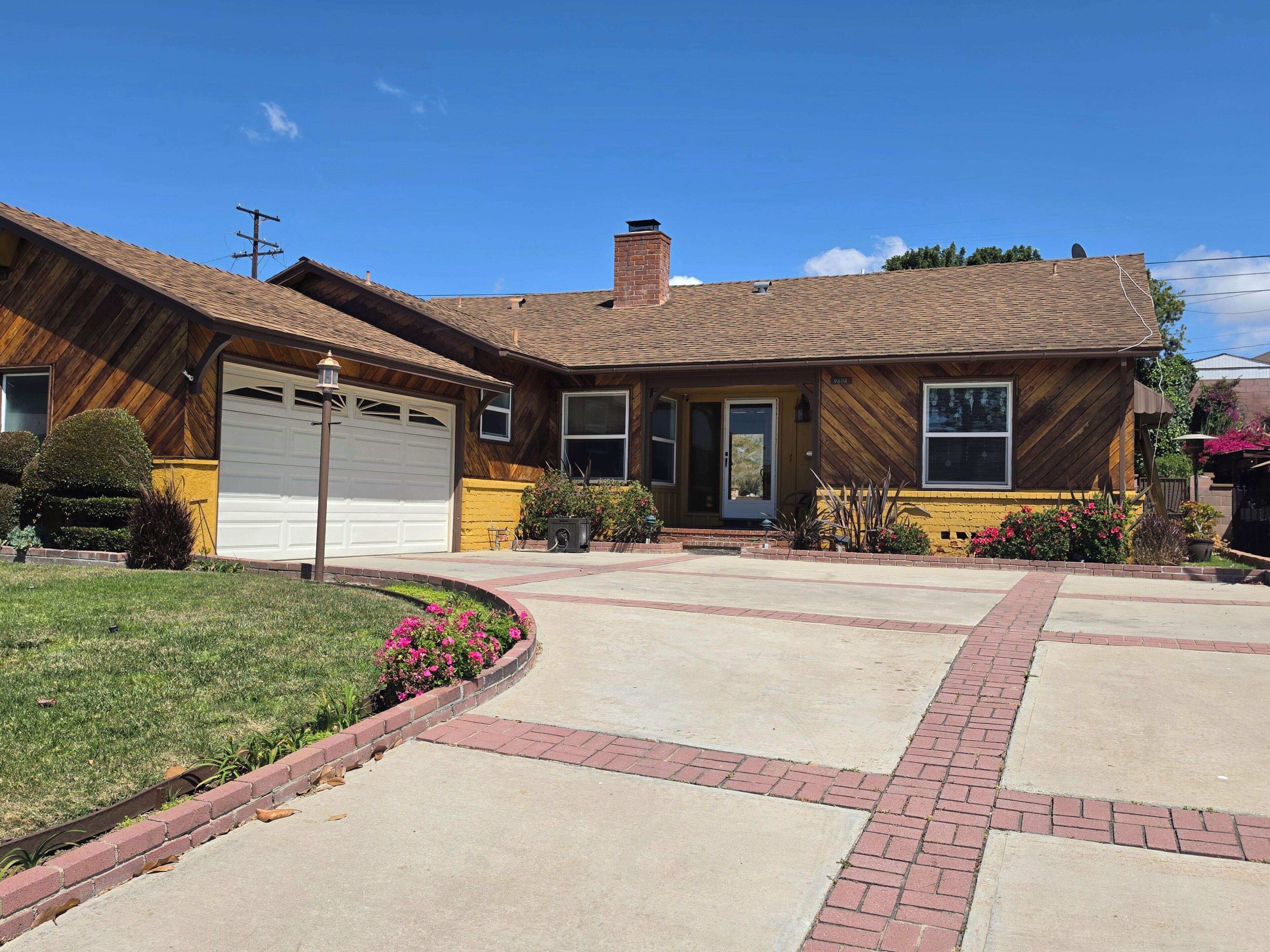 A two-story house with a garage, a front porch, and a well-maintained lawn.