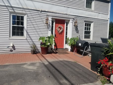 A house with a red door, white siding, and a brick driveway.. Boutique 1 BD, 1 BA downtown Hallowell apt with AC and free bicycles & kayaks