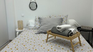 A neatly made bed with a polka dot bedspread, a bedside table with a lamp, and three wall-mounted mirrors. - Charming villa between sea and countryside in absolute calm (La Crau)