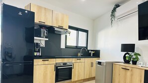 A modern kitchen with a refrigerator, oven, dishwasher, and a microwave. - Charming villa between sea and countryside in absolute calm (La Crau)