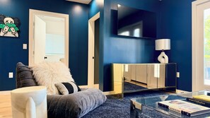 Ein modernes Wohnzimmer mit einer Couch, einem Couchtisch, einem Fernseher und einem Bücherregal.