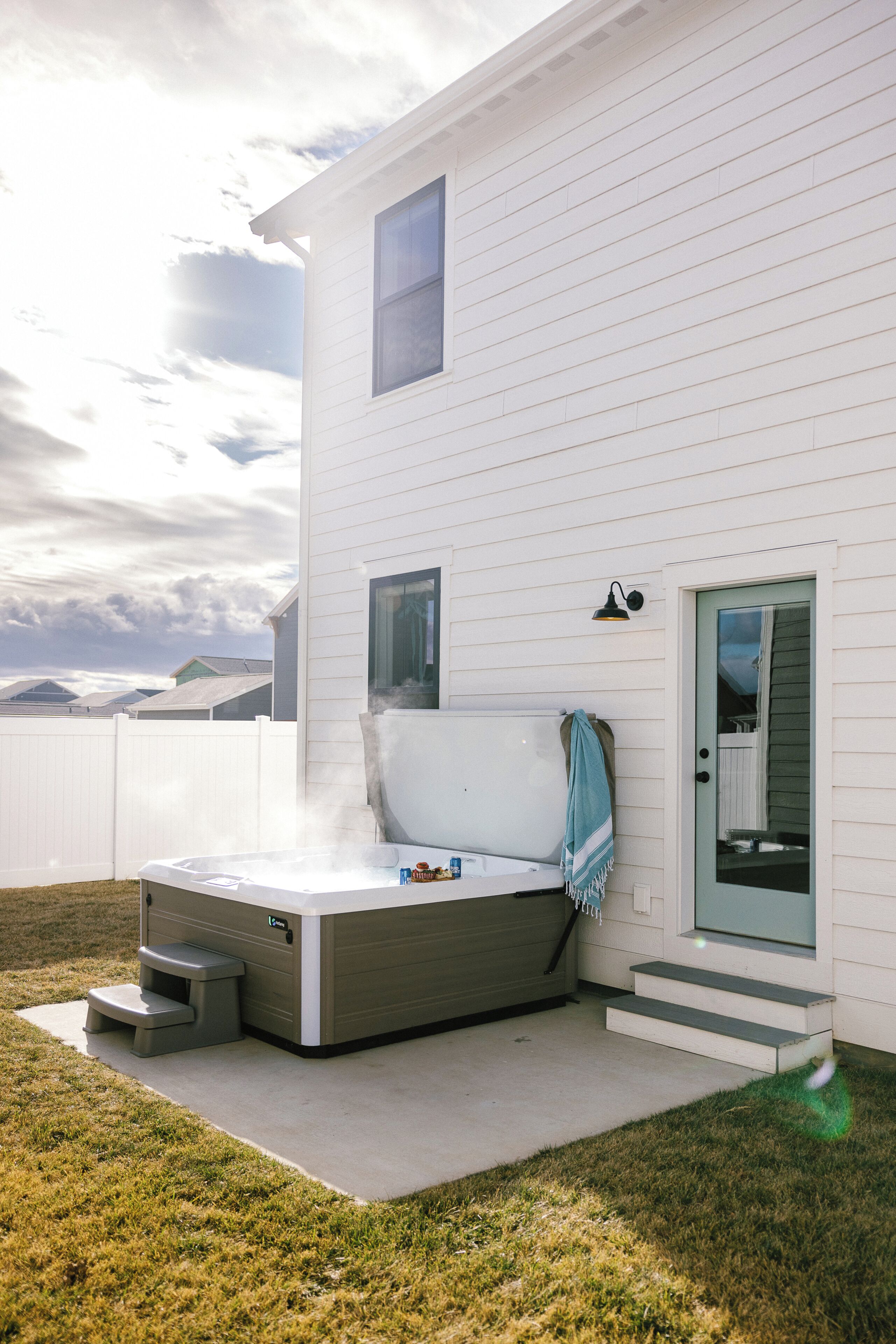 Ett modernt hus med en bubbelpool, en t äckt uteplats och utsikt över bergen.