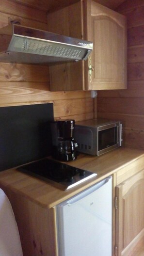 Eine kleine Küche mit Mikrowelle, Kaffeemaschine und kleinem Kühlschrank.