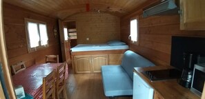 Ein kompaktes Wohnmobil-Interieur mit Küchenzeile, Essbereich und Schlafkoje.