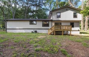 A two-story house with a wooden deck and a small porch. - 4-bedroom welcoming getaway in Jonesboro Ga (Jonesboro)