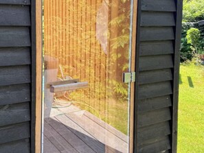 A wooden deck with a sliding glass door leading to a garden. - 4 Star Holiday Home in Tisvildeleje (Tisvildeleje)