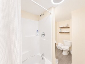 Ein modernes Badezimmer mit Badewanne, Toilette und Dusche.