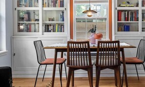Un comedor con una mesa y sillas, rodeado de estanterías.