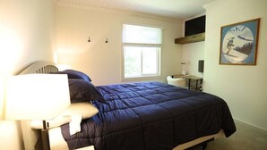 A bedroom with a bed, a desk, a chair, a window, and a painting on the wall. - Perfect Location at this Waterville Condo! (Waterville Valley)