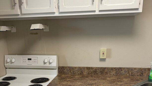 A kitchen with white cabinets, a granite countertop, a white stove, and a red towel. - Cozy 1 bedroom in a 2 bedroom apartment in charming Mayfield Heights. (Mayfield Heights)