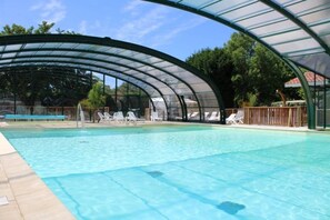 A swimming pool with a covered area and lounge chairs. - ZEcamping 4* animé piscine couverte dog friendly jacuzzi tente 2 pers (Azur)