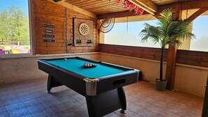 A pool table in a room with wooden walls, a dartboard, and a potted plant. - ZEcamping 3 étoiles pataugeoire piscine chalet 23m2 5 pers (Saint-Projet)