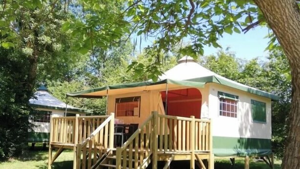 Una piccola costruzione in legno a un solo piano con un portico e una scala che porta a una porta.