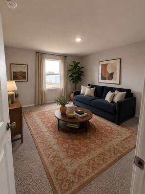 A living room with a sofa, a coffee table, a lamp, a plant, and a window with curtains. - Spacious 5-bedroom house in quaint Abilene with High-speed Internet (Abilene)