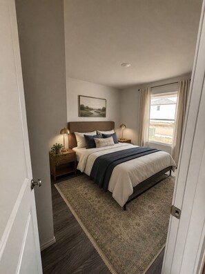 A bedroom with a bed, bedside lamps, a rug, a painting on the wall, and a window with curtains. - Spacious 5-bedroom house in quaint Abilene with High-speed Internet (Abilene)