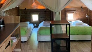 Ein gemütliches Schlafzimmer im Dachgeschoss mit zwei Betten, einem hölzernen Schminktisch und einer Pendelleuchte.