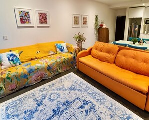 A living room with two sofas, a patterned rug, and wall art. - Free Car Space + Collins 2BR Full Apartment (West Melbourne)