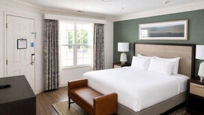 A hotel room with a large bed, a desk, a chair, a nightstand with lamps, and a painting on the wall. - Relaxing Resort Condo for 6 guests, In The Heart of Beautiful Branson! (Branson)