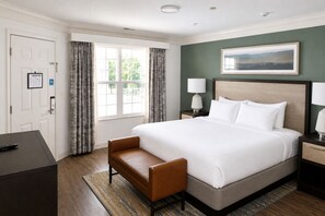 A hotel room with a large bed, a desk, a chair, a nightstand with lamps, and a painting on the wall. - Relaxing Resort Condo for 6 guests, In The Heart of Beautiful Branson! (Branson)