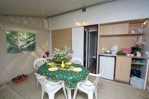 Eine kleine Küche mit Kühlschrank, Spüle und Holzschränken.