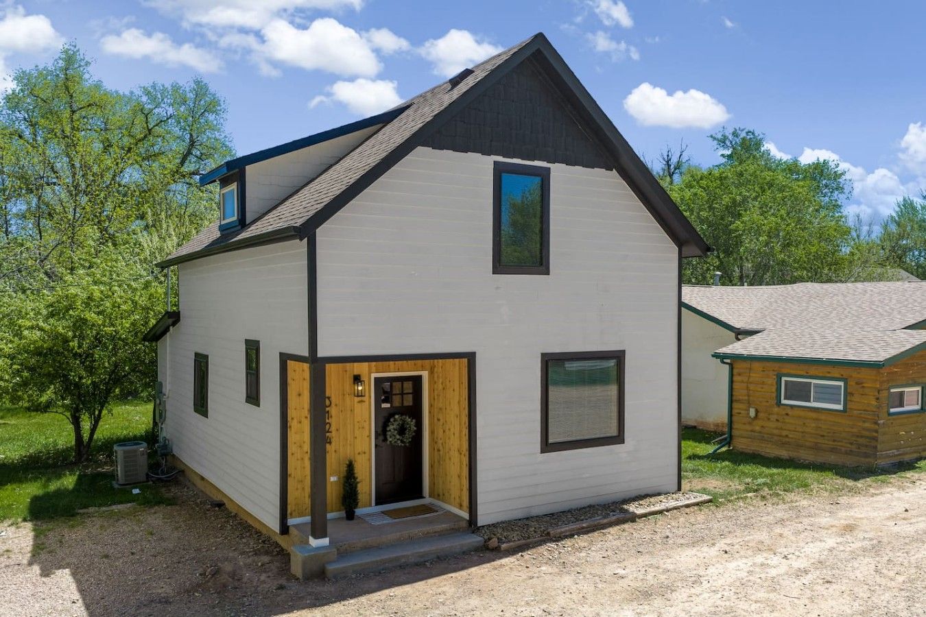 A two-story building with a front door, a small porch, and a visible chimney.