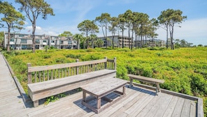 A wooden deck with benches, surrounded by greenery and a building in the background. - Oceanfront Complex - New Rental
- Steps to Beach/Pool/Coligny 
- Sleeps 6pp (Hilton Head Island)