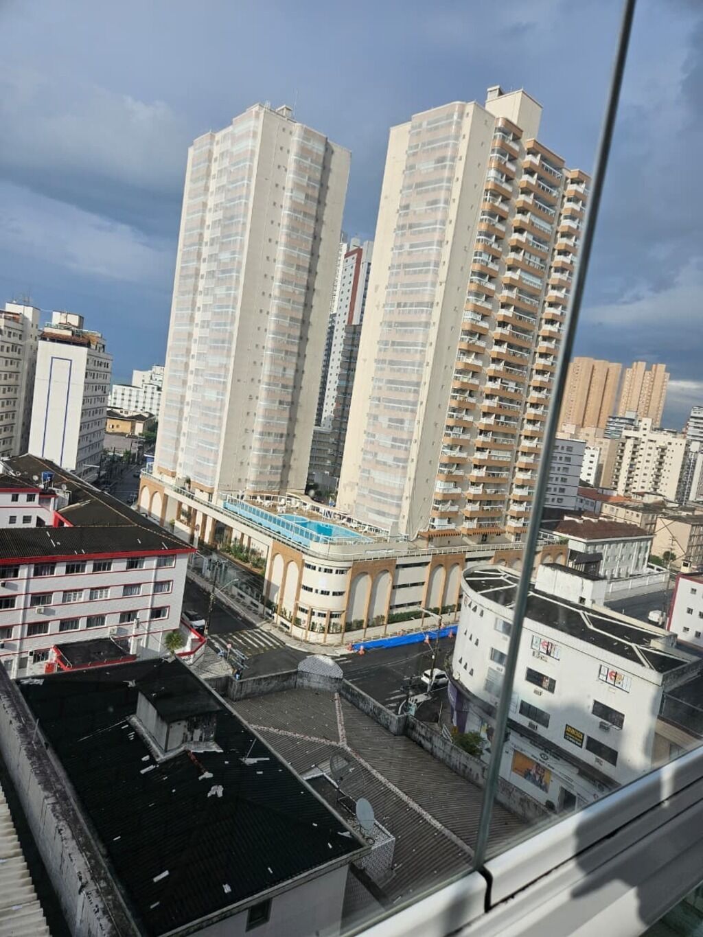 Ein Hochhaus mit mehreren Stockwerken, einer Dachterrasse und Blick auf umliegende Stadtgebäude.