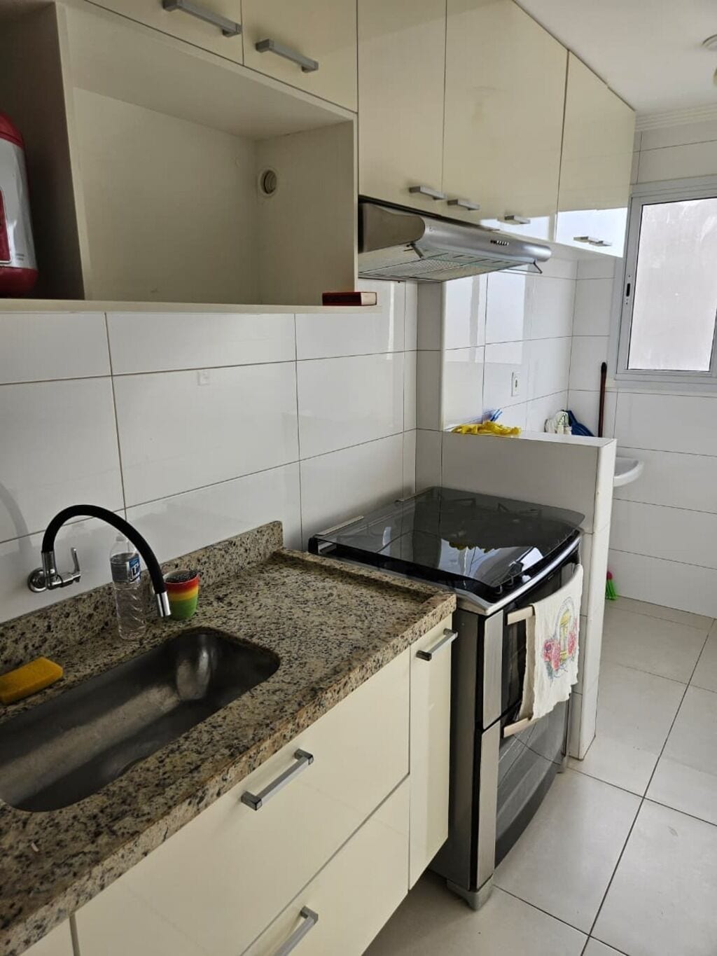 Eine Küche mit Granit Arbeitsplatte, Edelstahlgeräten und weißen Schränken.