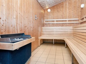 Eine Sauna mit Holzbänken und einem Ruhebänkchen.
