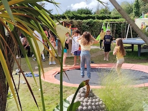 A trampoline in an outdoor setting with people around it. - Camping 3 étoiles - Piscine  - ccbfidh (Les Moutiers-en-Retz)