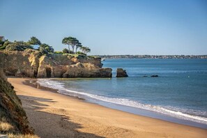 A beach with clear water, a sandy shore, and rocky cliffs. - Camping 3 étoiles - Piscine  - ccbfidh (Les Moutiers-en-Retz)