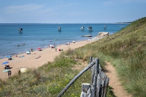 A beach with a sandy shore, a wooden fence, and a clear sky. - Camping 3 étoiles - Piscine  - ccbfie0 (Les Moutiers-en-Retz)