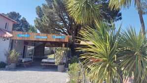 Eine Holzhütte mit Schildern für 'SNACK', 'LE P'tit Prigny' und 'BAR'.