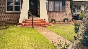 A single-story house with a front entrance, a small porch, and a well-maintained lawn. - Large, comfortable home, great location, 4 bedroom, washer/dryer, pet friendly (Mobile)